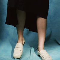 Finley Beige Leather Loafers, styled with a black asymmetric hem dress - POEVE Collection