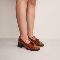 Kendra Brown Patent Leather Heel Loafers with Leather Tassel, worn on bare legs - POEVE Collection