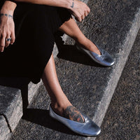 Reese Silver Laminated Leather Ballerinas, worn with a black skirt - POEVE Collection