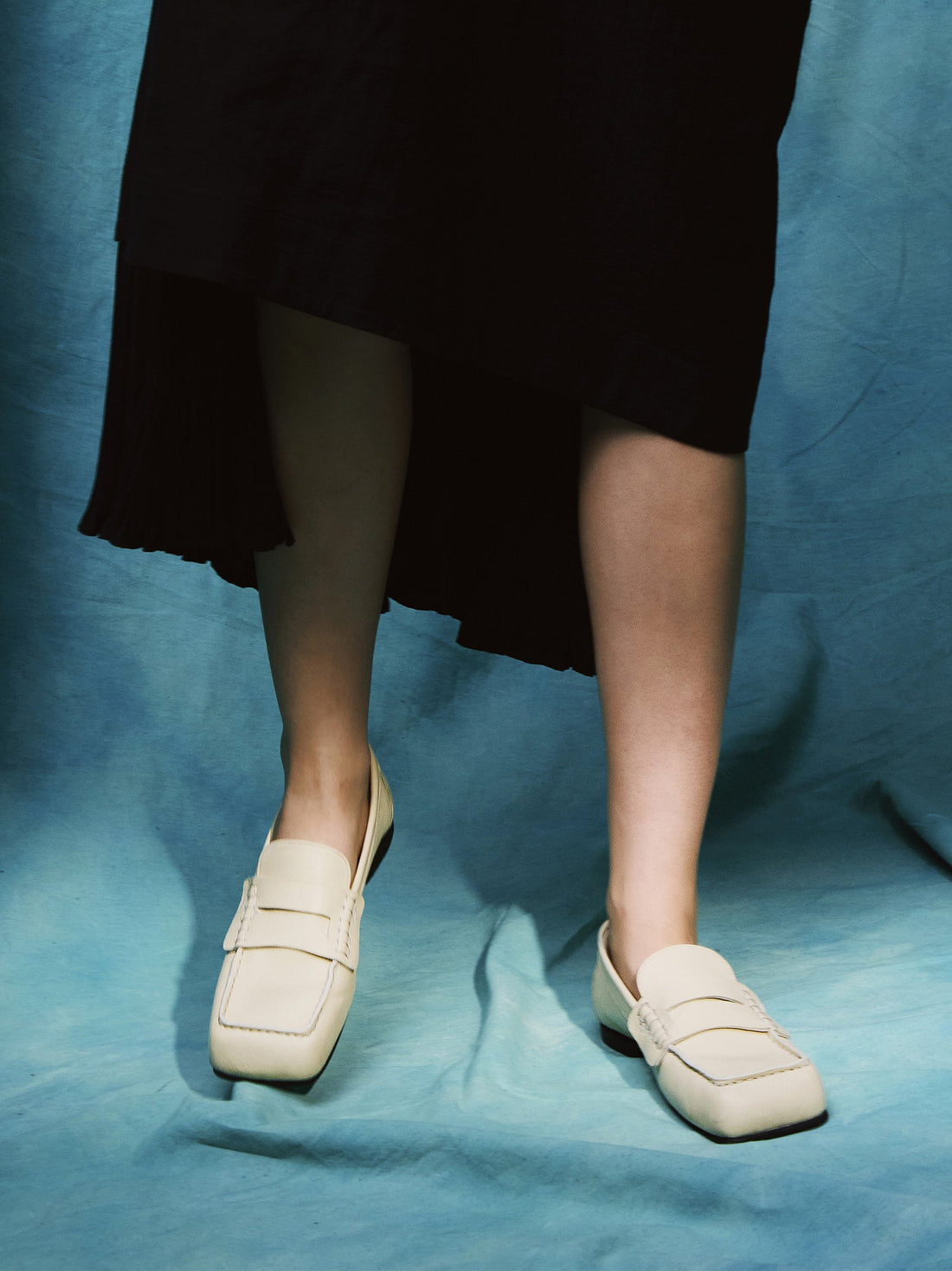 Finley Beige Leather Loafers, styled with a black asymmetric hem dress - POEVE Collection