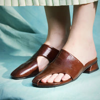 Melanie Brown Crinkled Patent Leather Mules, styled with a mint green pleated skirt - POEVE Collection