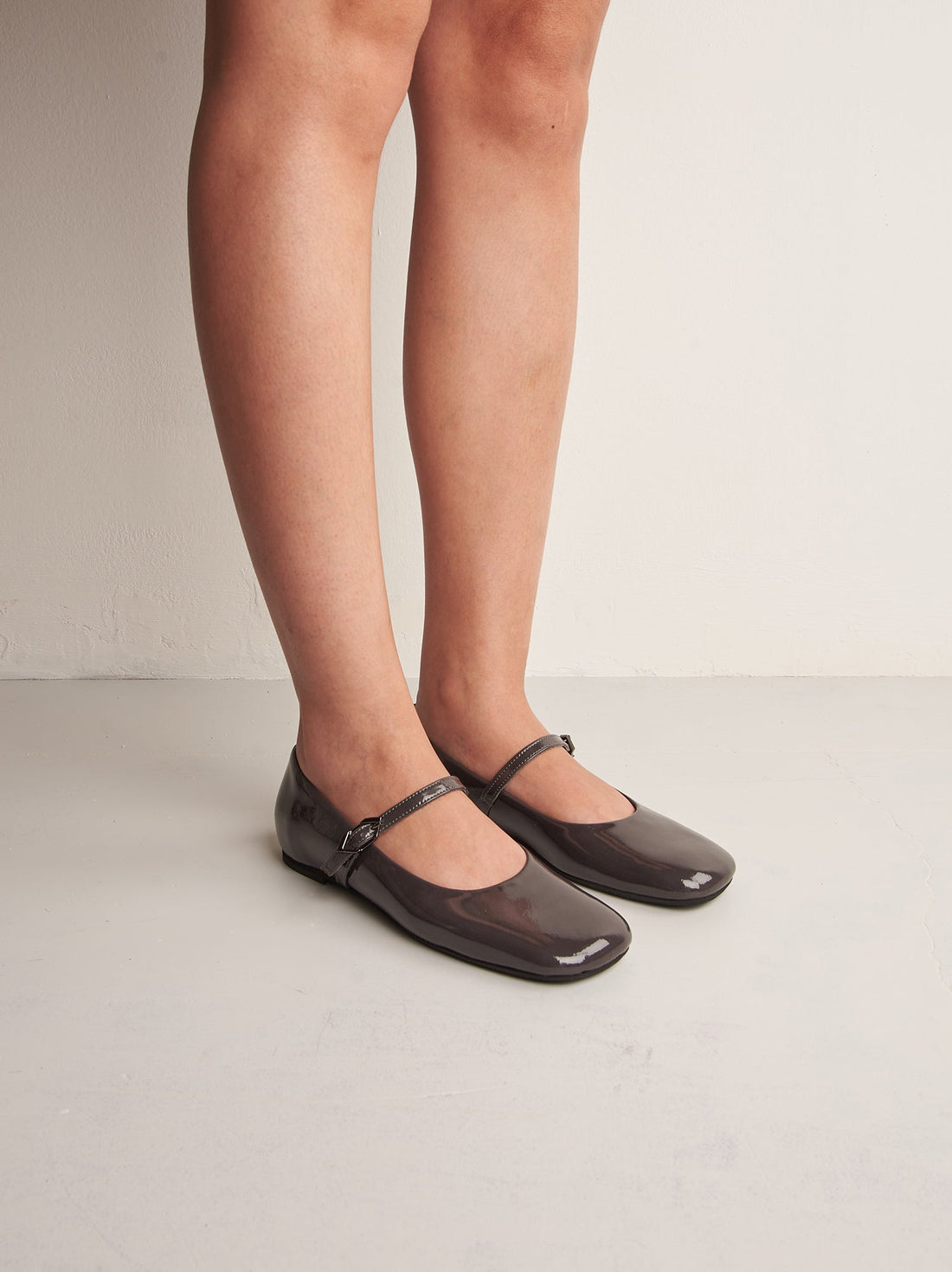 Aurora Grey Patent Leather Ballerinas, worn on bare legs - POEVE Collection