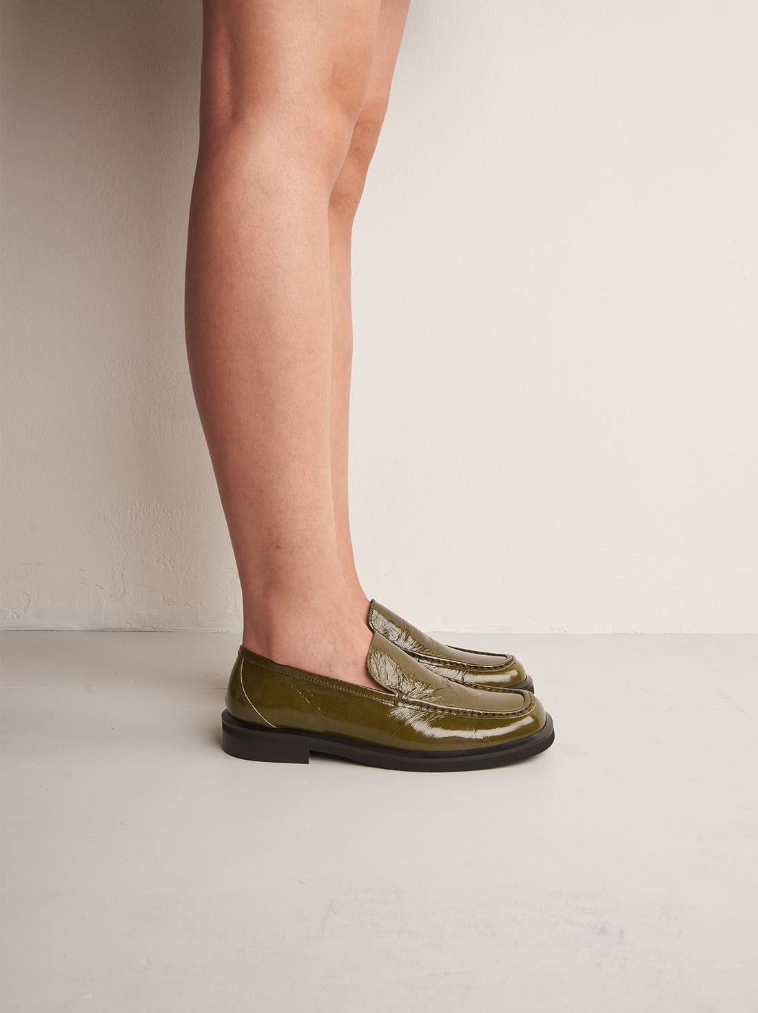 Dannie Green Crinkled Patent Leather Loafers, worn on bare legs - POEVE Collection