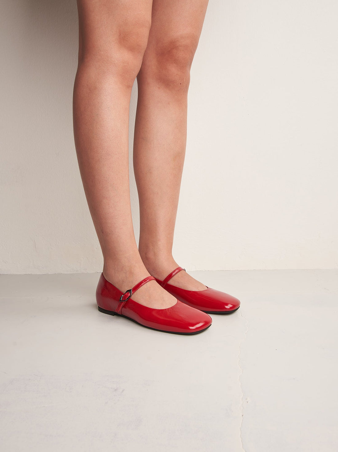 Aurora Red Crinkled Patent Leather Ballerinas, worn on bare legs - POEVE Collection