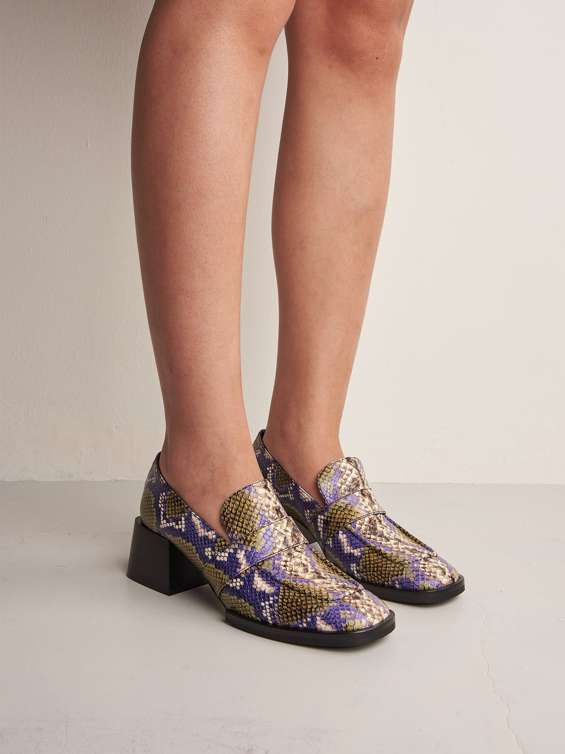 Noemi Snake-embossed Leather Heel Loafers, worn on bare legs - POEVE Collection