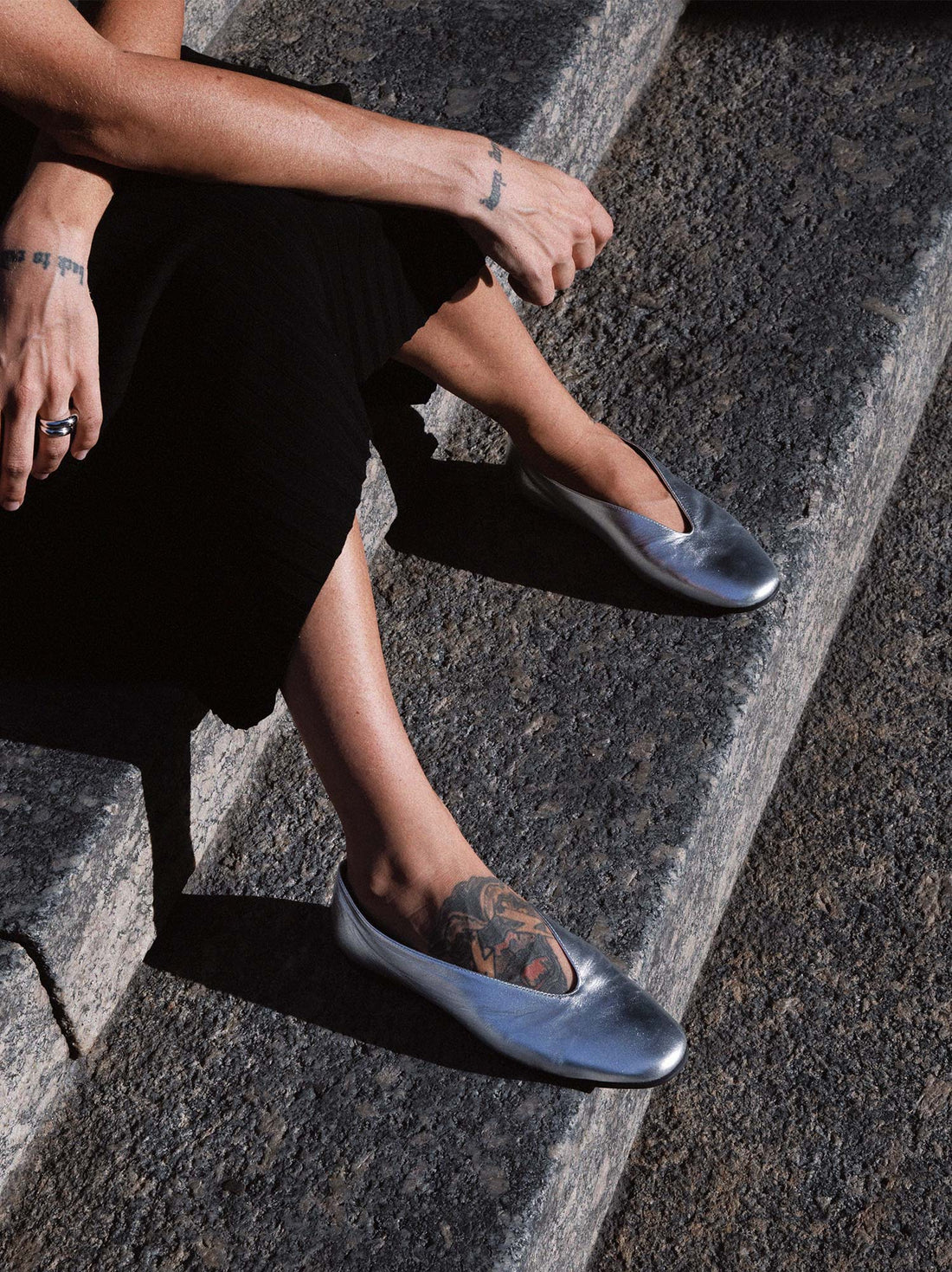 Reese Silver Laminated Leather Ballerinas, worn with a black skirt - POEVE Collection
