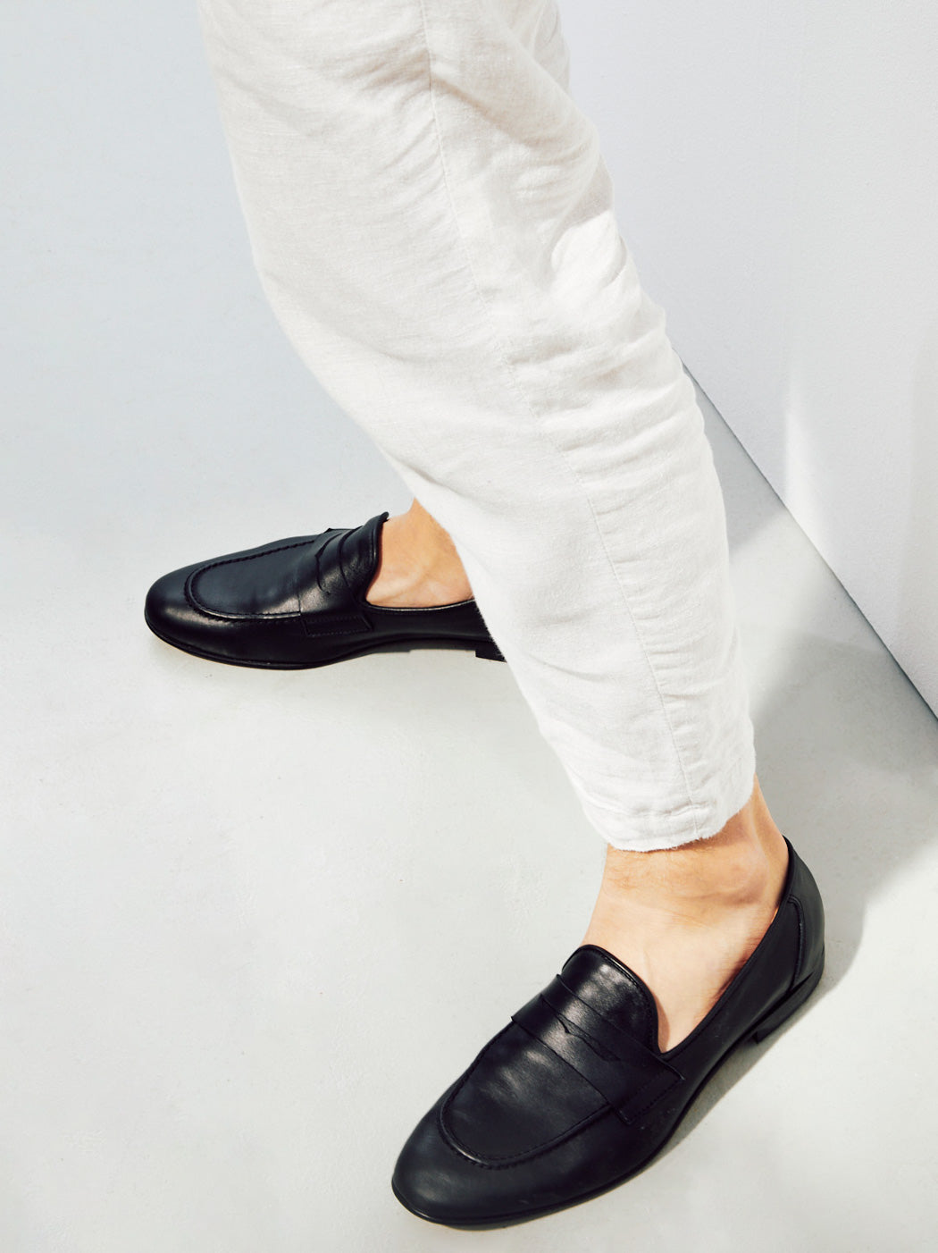 Oscar Black Leather Penny Loafers, styled with white linen trousers - POEVE Collection