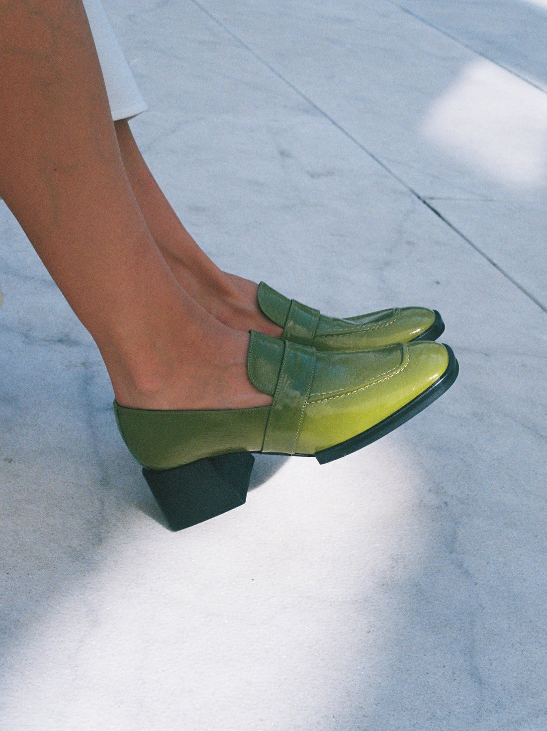 Noemi Green Crinkled Patent Leather Heel Loafers, worn on bare legs - POEVE Collection