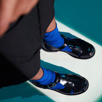 Raven Black Brushed Leather Fisherman Sandals, styled with vibrant cobalt blue socks - POEVE Collection