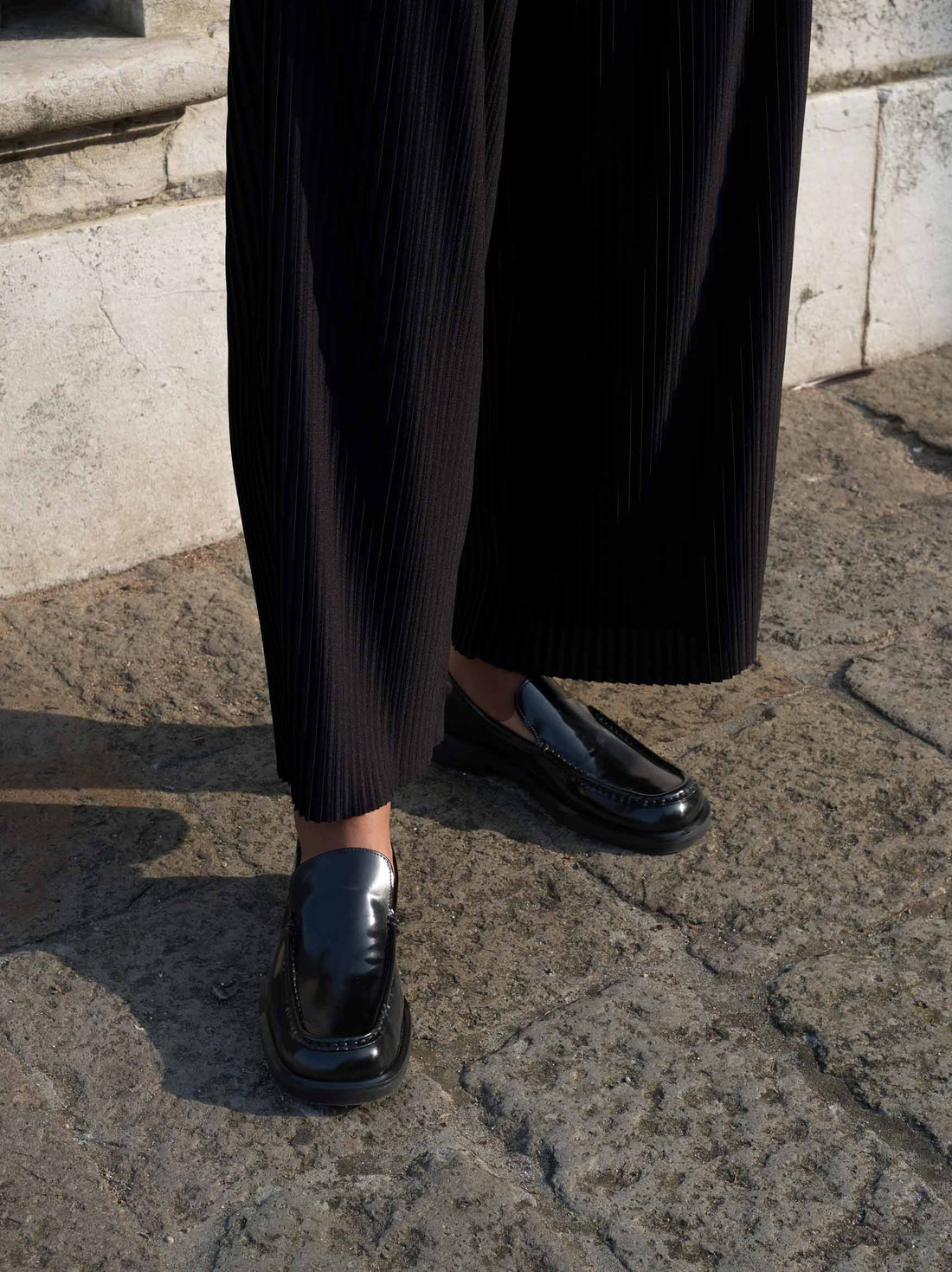 Dannie Black Brushed Leather Loafers, styled with pleated wide-leg trousers - Side View - POEVE Collection