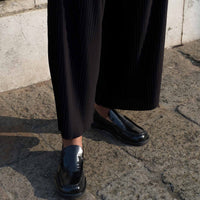 Dannie Black Brushed Leather Loafers, styled with pleated wide-leg trousers - Side View - POEVE Collection